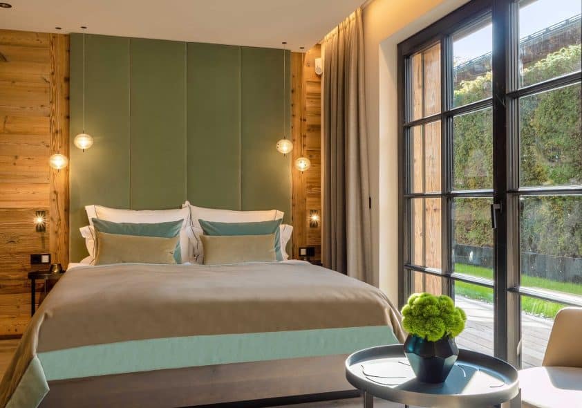 Schlafzimmer des Alpin-Chalets mit Doppelbett und Gartenzugang