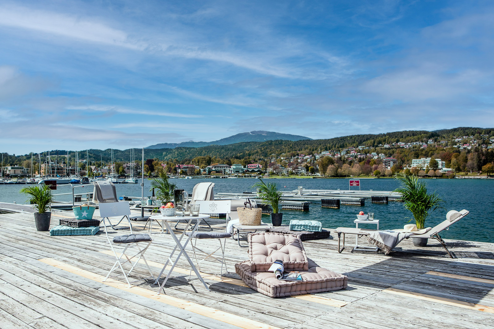 Panoramaterrasse mit Strandmöbel am Ufer eines Sees.