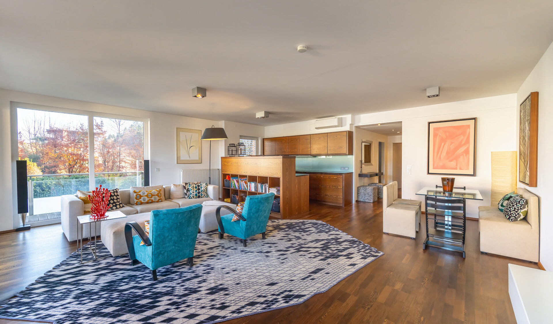 Helles Wohnzimmer mit bunten Couchsesseln und stilvoller Einrichtung