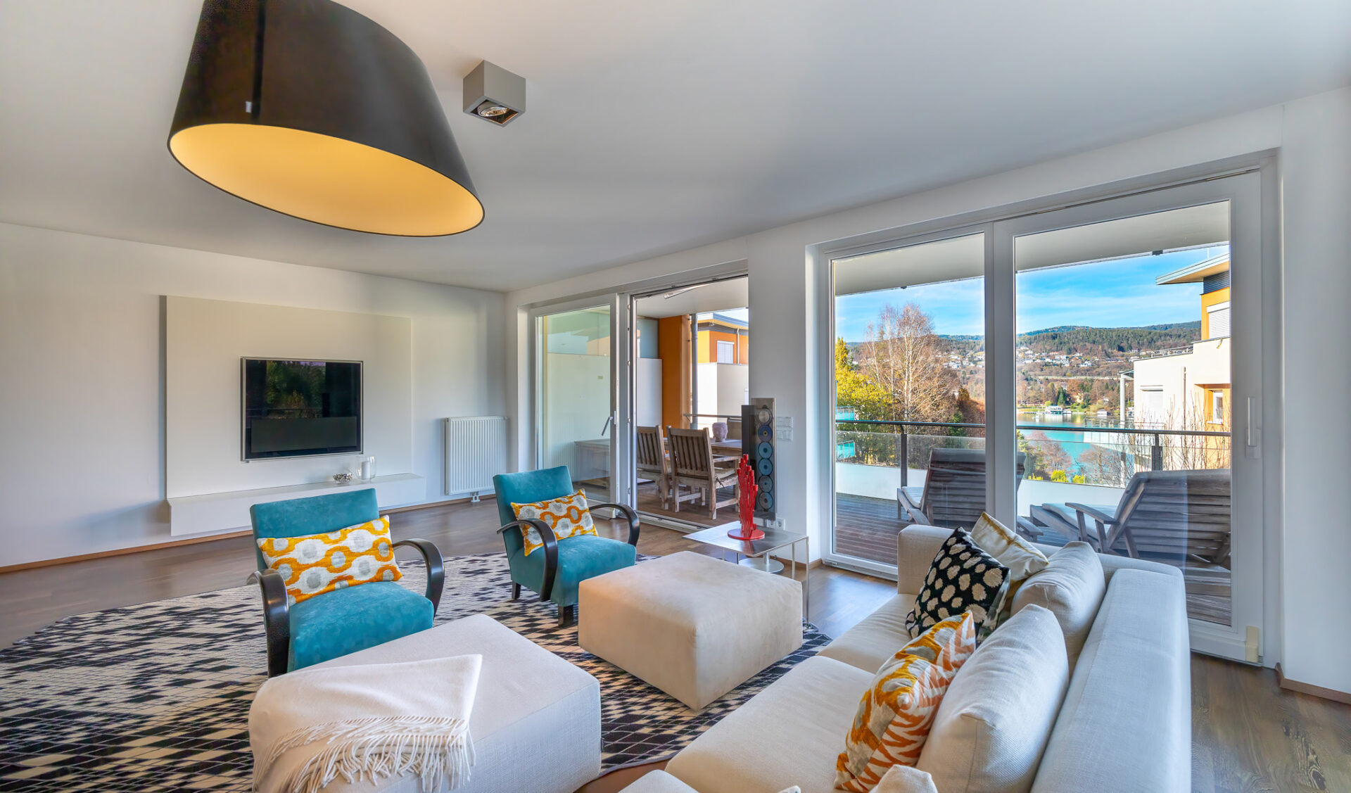 Helles Wohnzimmer mit Ausblick auf Panoramaterrasse.