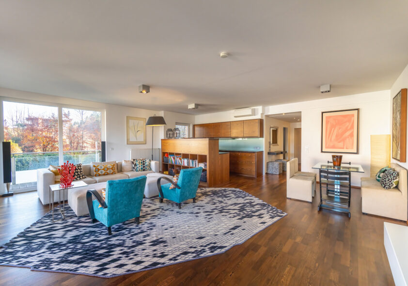 Helles Wohnzimmer mit bunten Couchsesseln und stilvoller Einrichtung