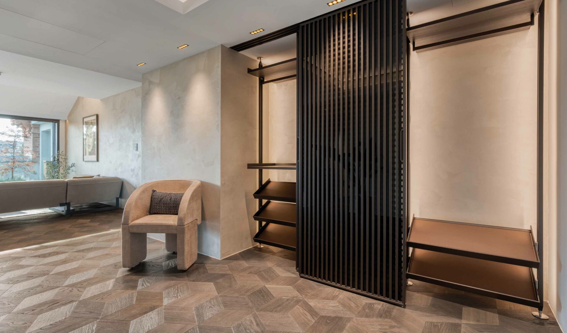 Moderner Ankleidebereich mit Lamellen-Raumteiler, offenem Regalsystem und Fischgrätparkett.