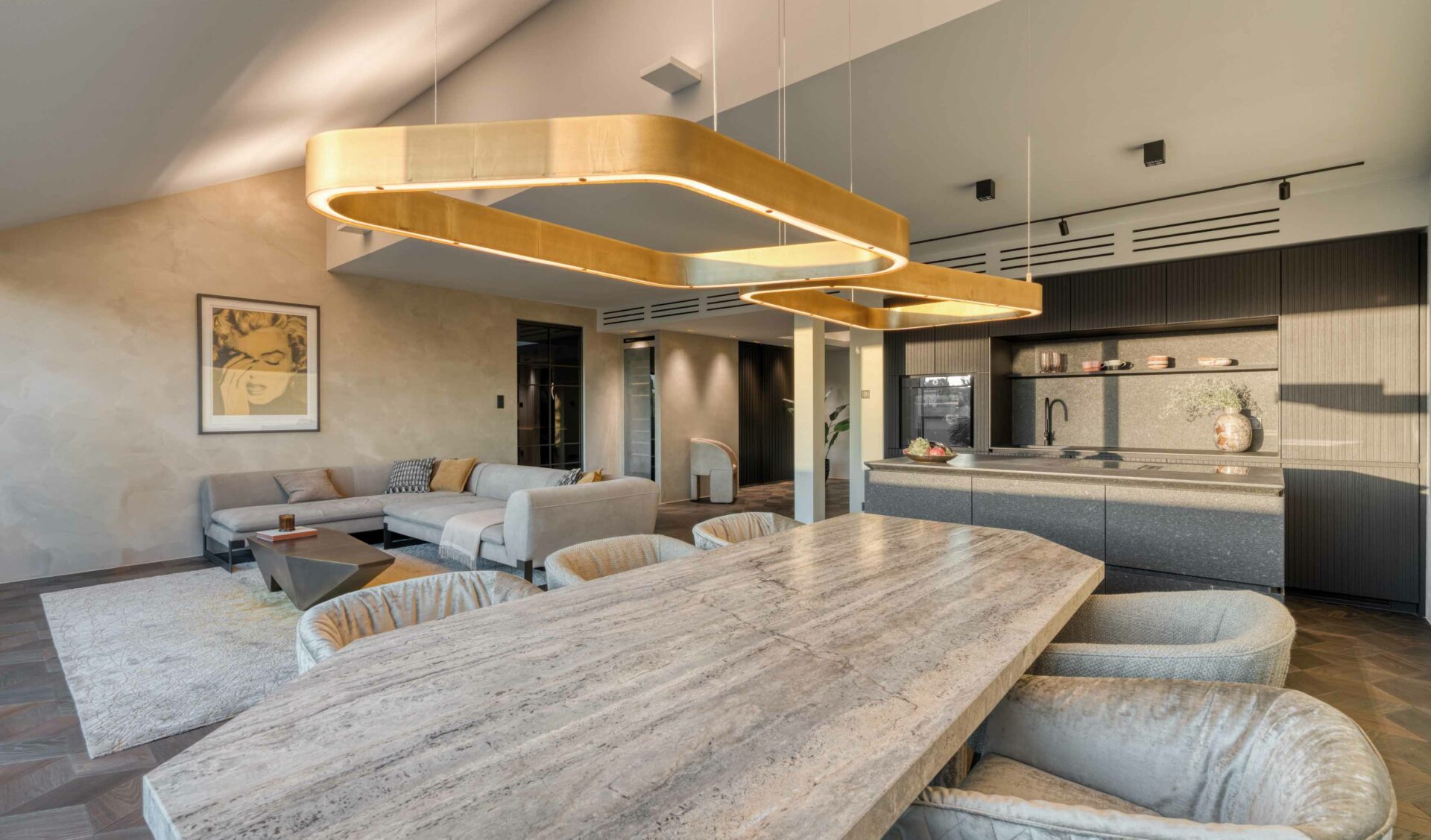 Moderner offener Wohnbereich mit großem Holz-Esstisch, Designer-Pendelleuchte und integrierter Küche.