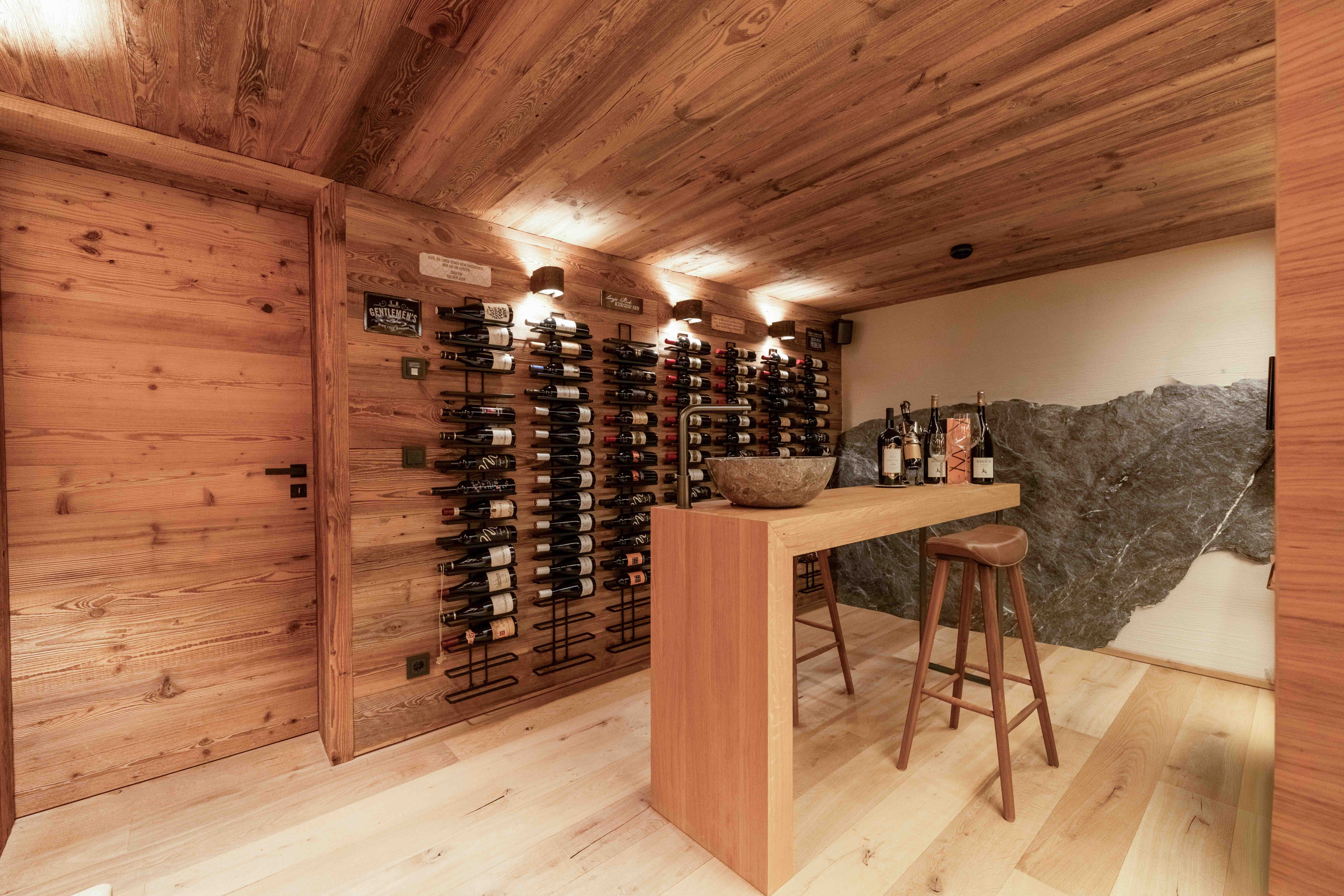 Chalet-Weinkeller mit Wandregalen, Verkostungstheke und vollständiger Holzvertäfelung.