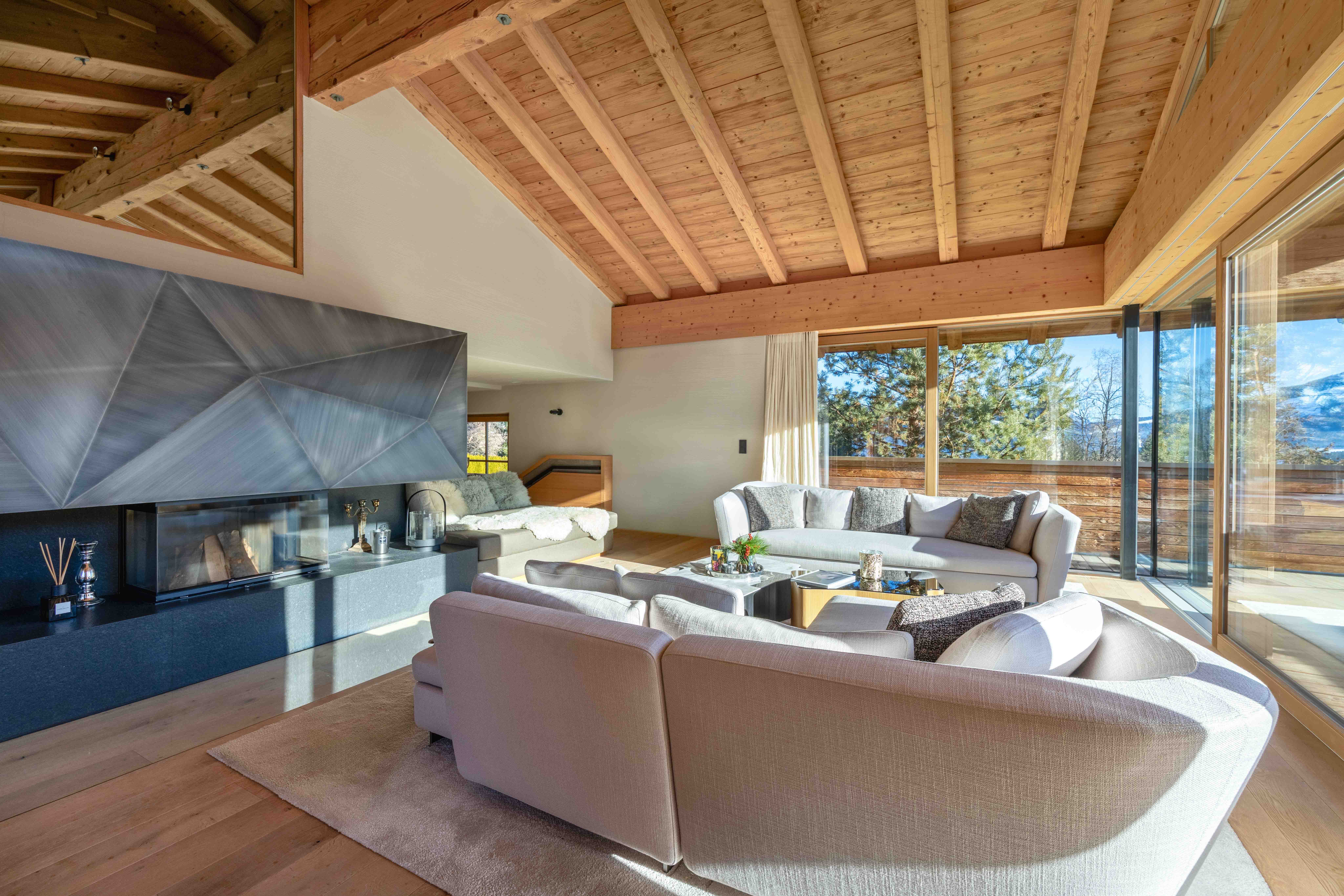 Luxuriöses Landhaus-Wohnzimmer mit modernem Designer-Kamin, beigen Sofas und Terrassenzugang.