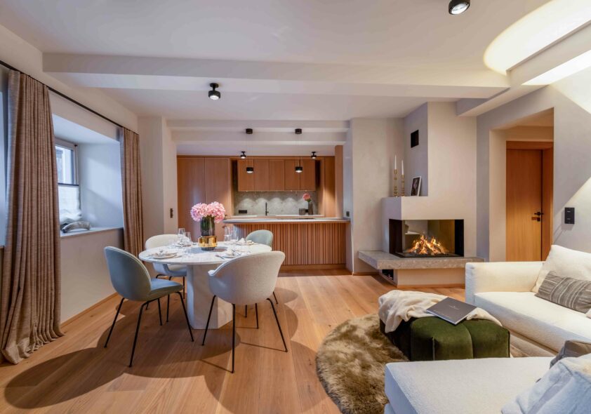 Moderne offene Stadtwohnung mit Essbereich, Küchenzeile und Kamin in hellem Design.