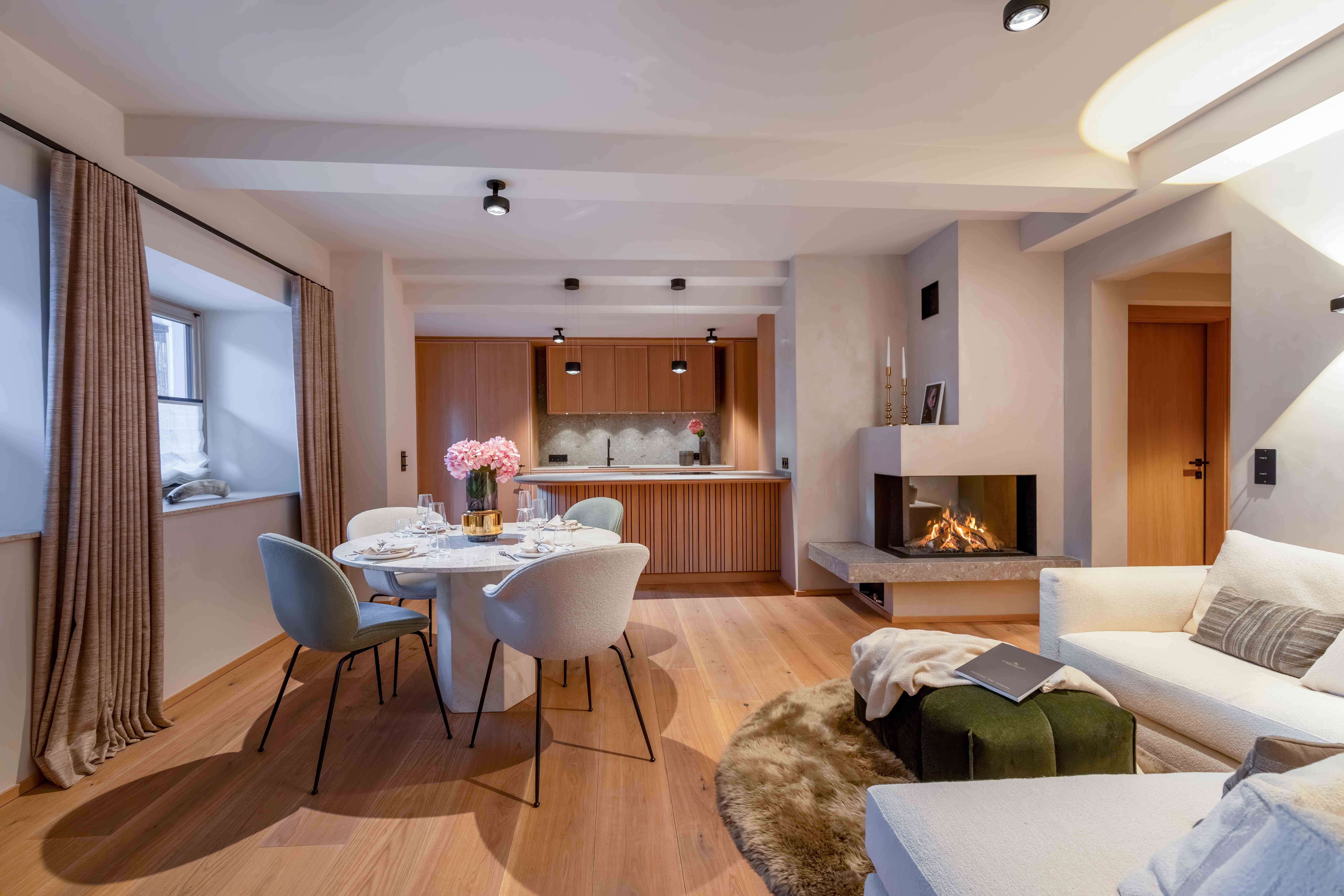 Moderne offene Stadtwohnung mit Essbereich, Küchenzeile und Kamin in hellem Design.
