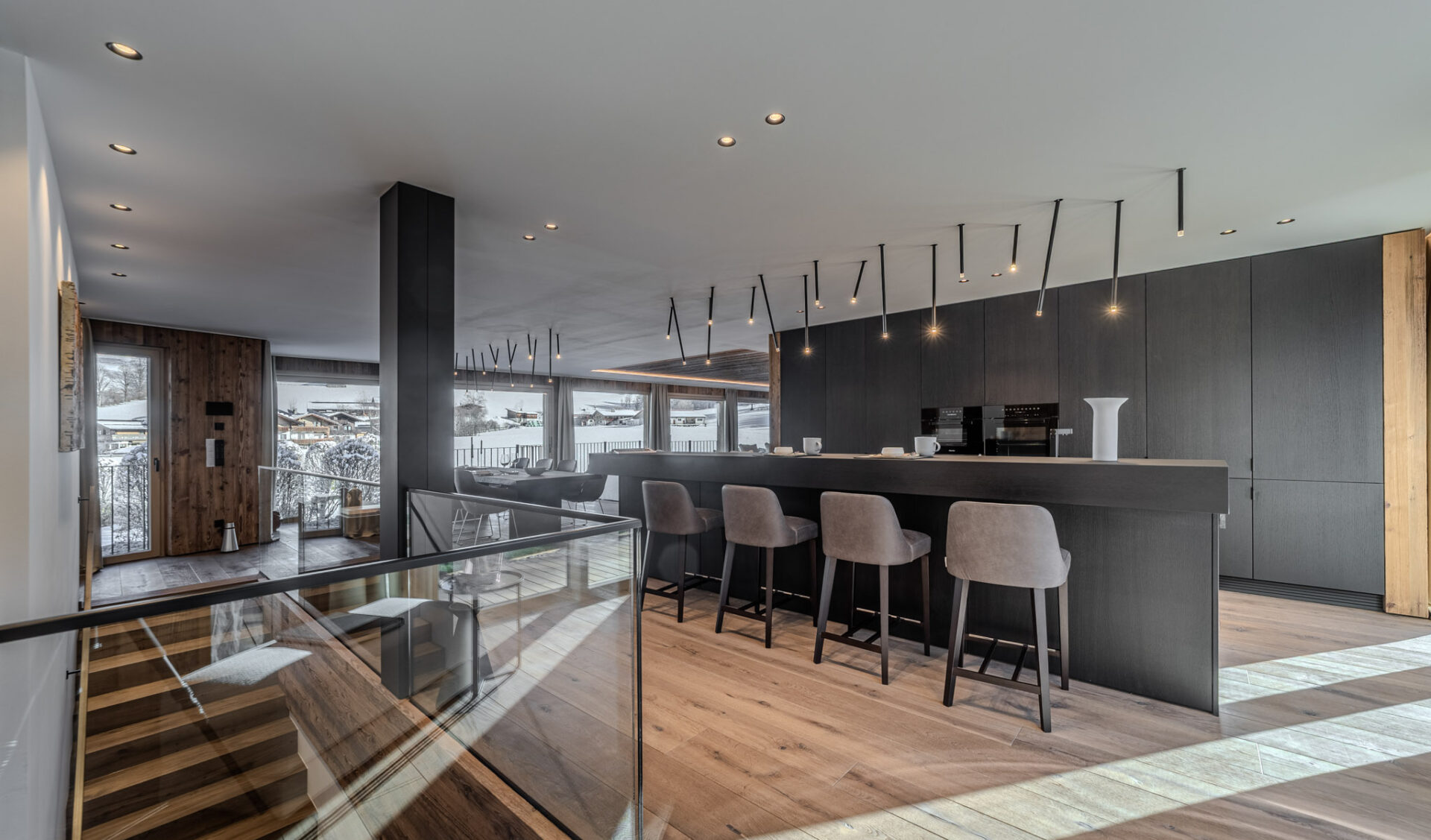 Zeitgemäße Gartenwohnung-Küche mit großer Kochinsel, Bar-Seating und Bergpanorama.