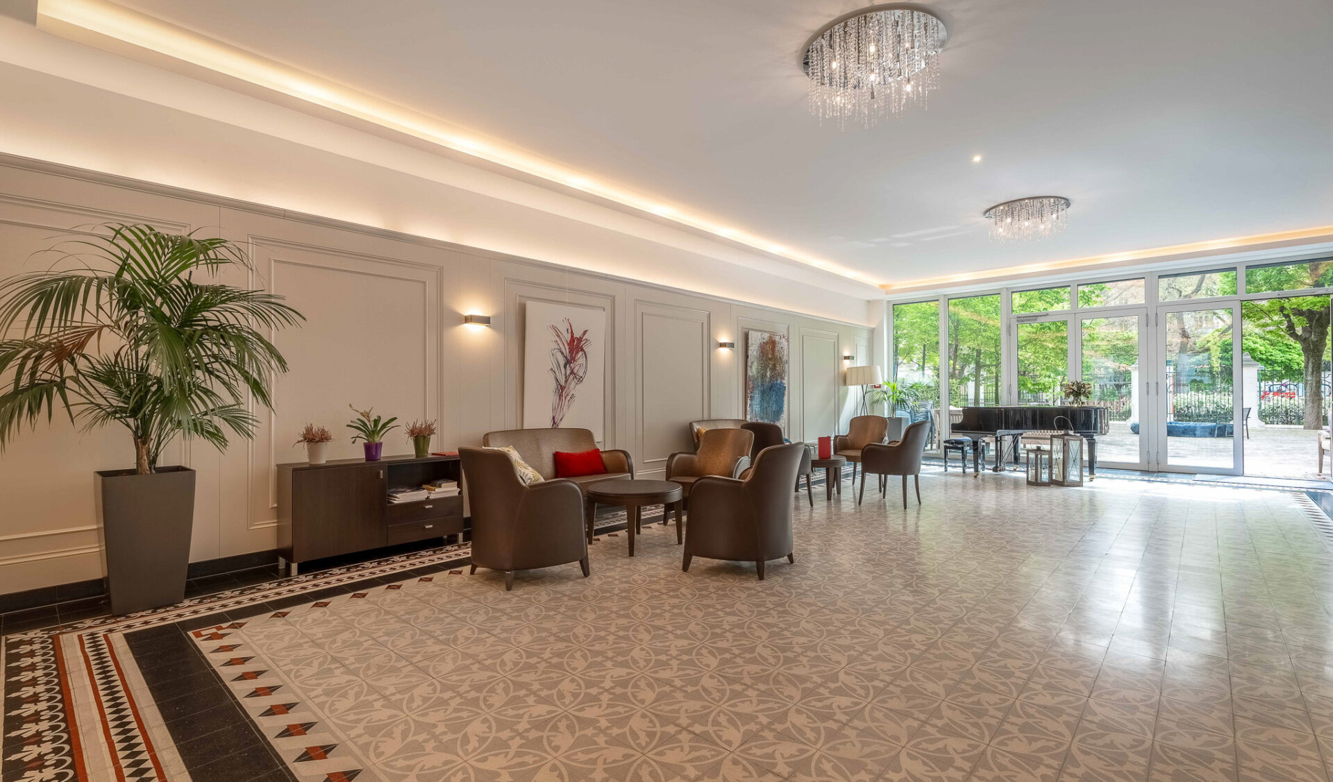 Luxuriöse Wohnhaus-Lobby mit Kristallkronleuchtern, Ledersesseln, indirekter Beleuchtung und Musterfliesen.