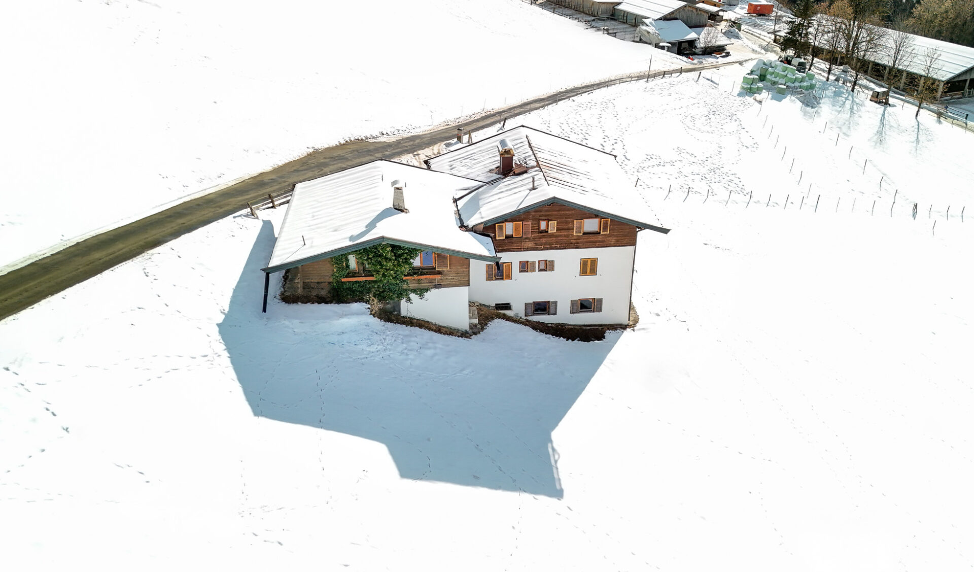 Luftaufnahme privates Grundstück mit Chalet, ebene Fläche und direkte Straßenanbindung.