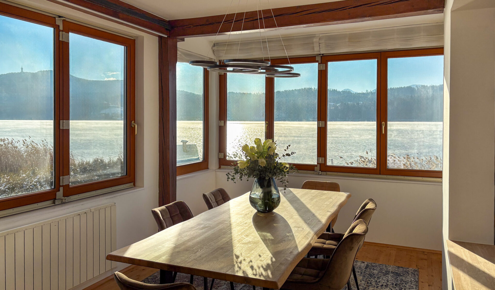 Helles Esszimmer mit Seeblick & Naturverbindung, großem Holztisch und Panoramafenstern.