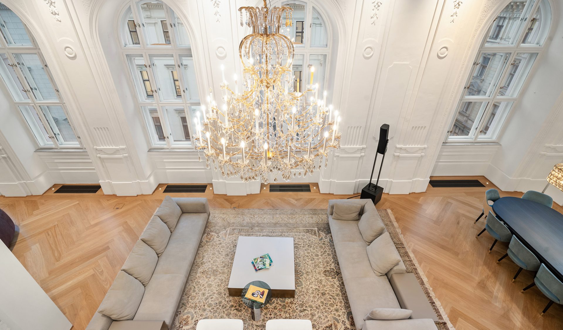 Großzügiger Maisonette-Wohnbereich mit historischem Stuck, Goldkronleuchter und modernem Interieur.