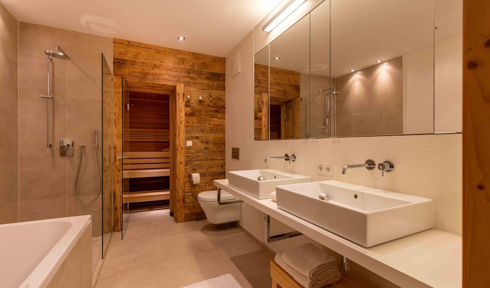 Luxus-Badezimmer mit privater Altholz-Sauna, Doppelwaschbecken, Badewanne und Glasdusche.