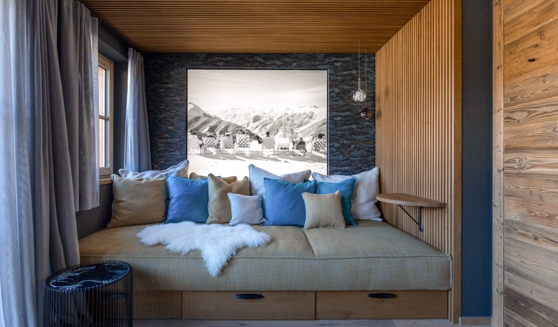 Stilvoller Wellnessbereich mit Holzverkleidung, Natursteinwand und alpinem Kunstwerk.