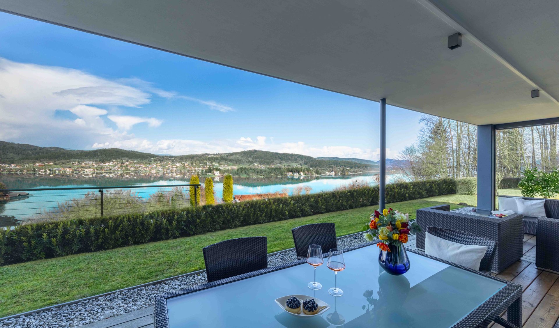 Premium-Seeterrasse mit Panoramablick auf Wörthersee, gegenüberliegendes Ufer und Bergkulisse.