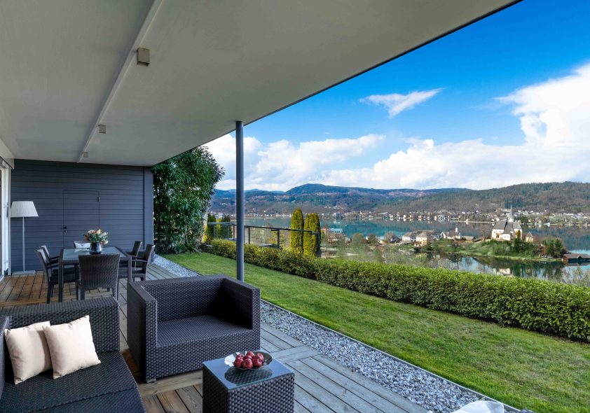 Exklusive überdachte Terrasse mit Designer-Lounge, gepflegtem Garten und Wörthersee-Panorama.