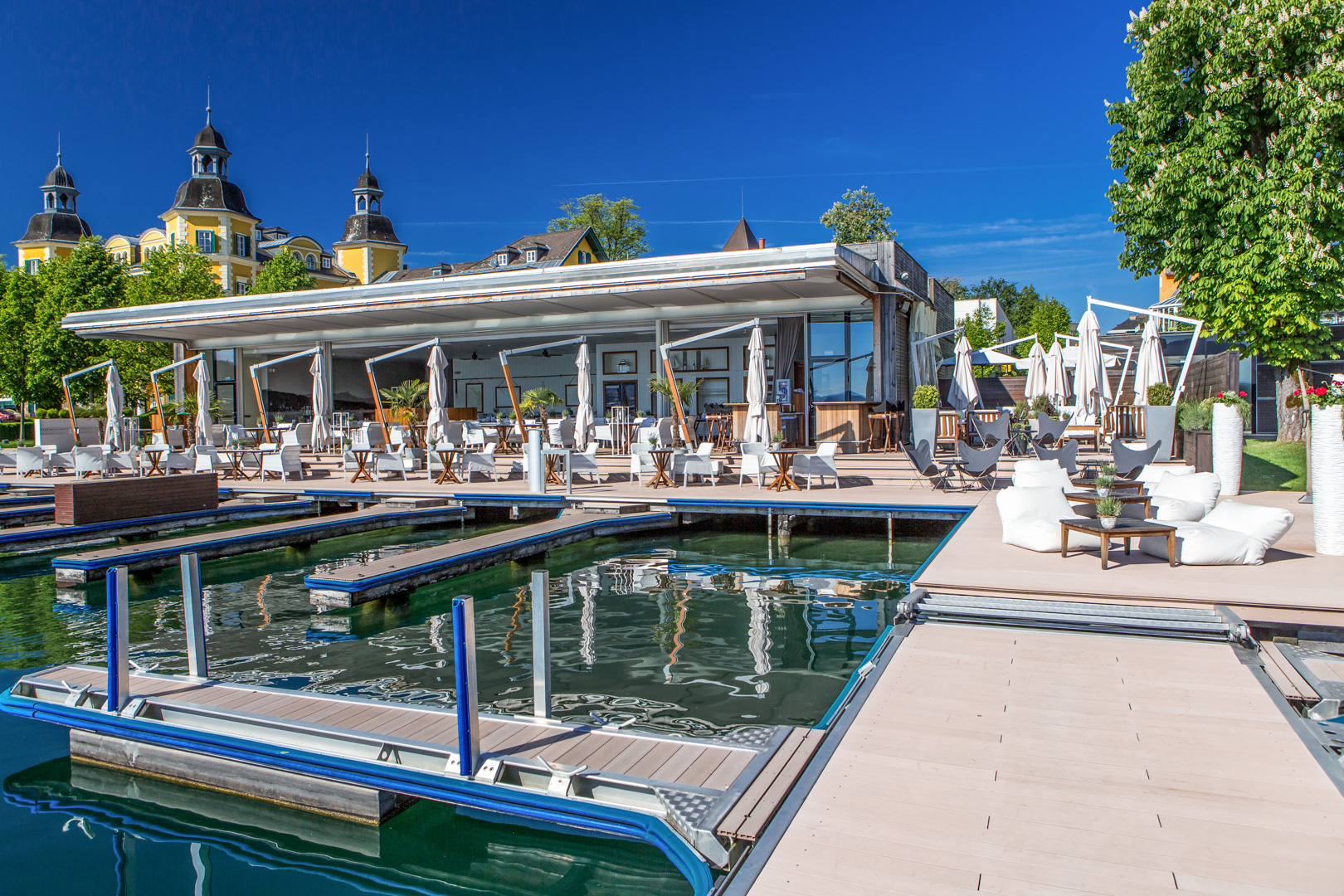 Exklusiver Beach Club am Wörthersee mit Bootsanlegestellen und Restaurantbereich. Teil der 5-Sterne-Hotelanbindung.