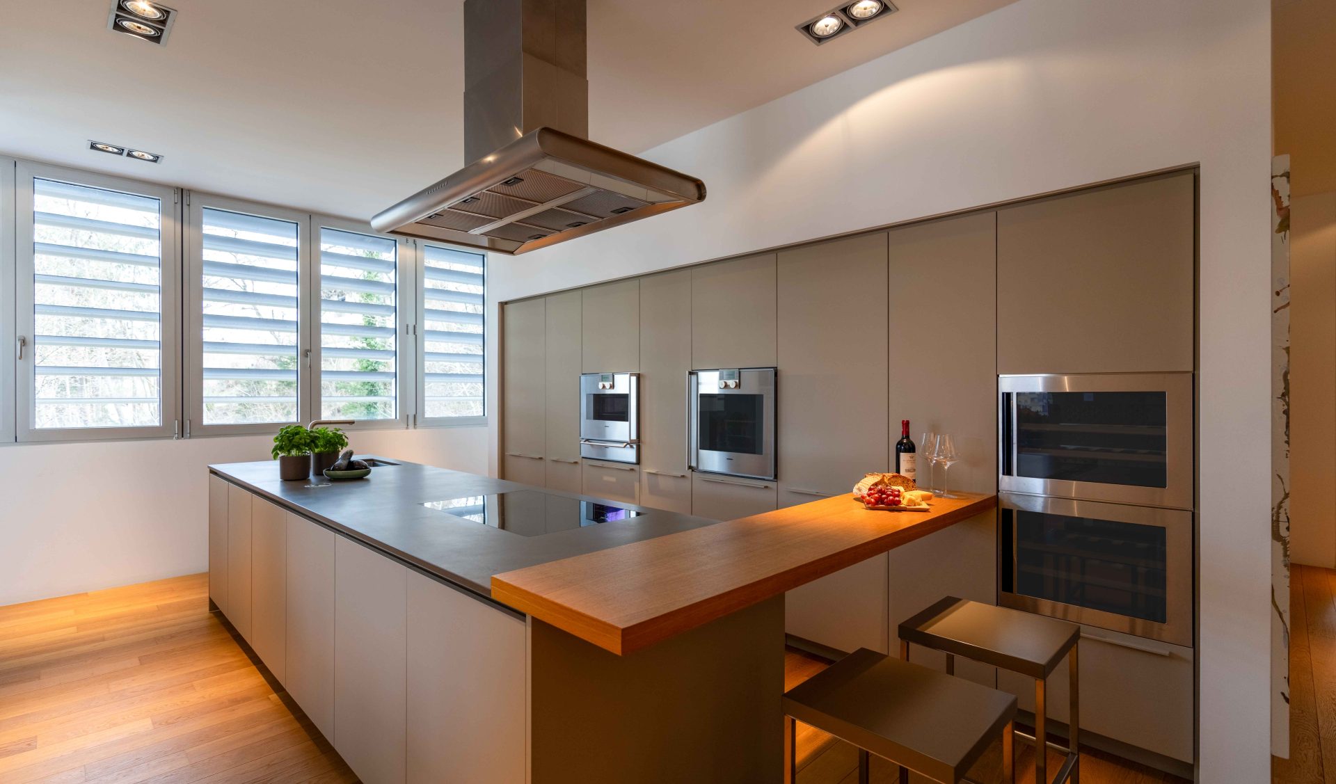 Moderne Design-Küche mit Kochinsel, integrierter Frühstücksbar und hochwertigen Einbaugeräten im Apartment Schloss Velden.