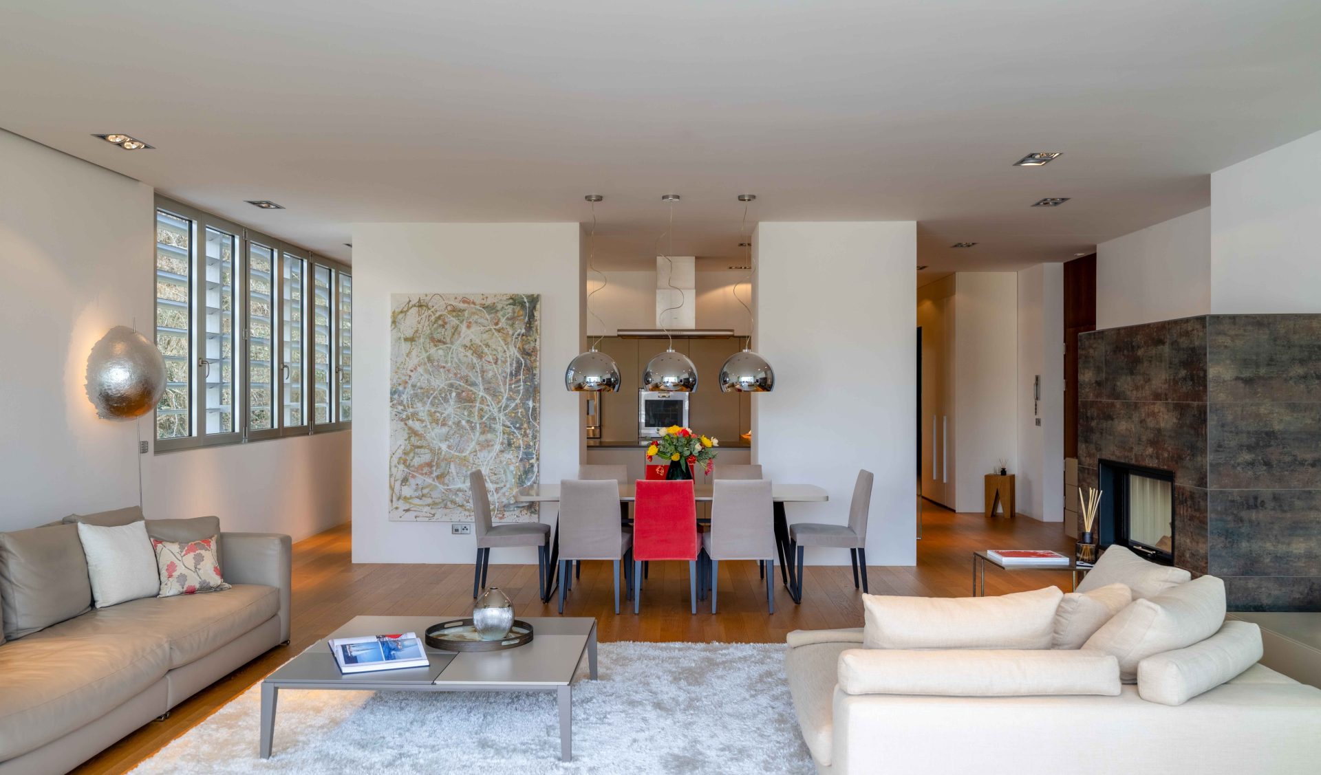 Exklusives Interior Design im Wohn- und Esszimmer mit hochwertigem Parkett, Designer-Leuchten und fließendem Übergang zur Küche.