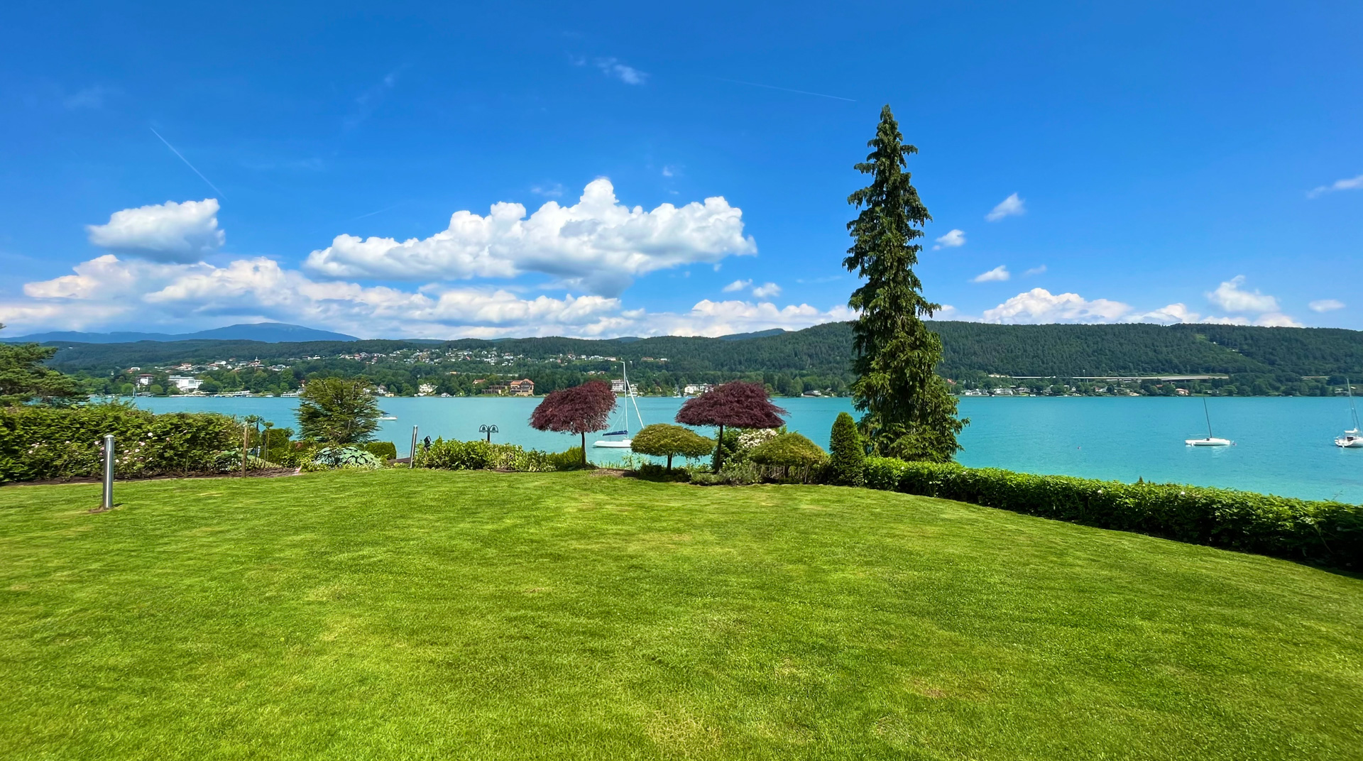 Gepflegter Garten mit Panoramablick auf den türkisfarbenen Wörthersee.