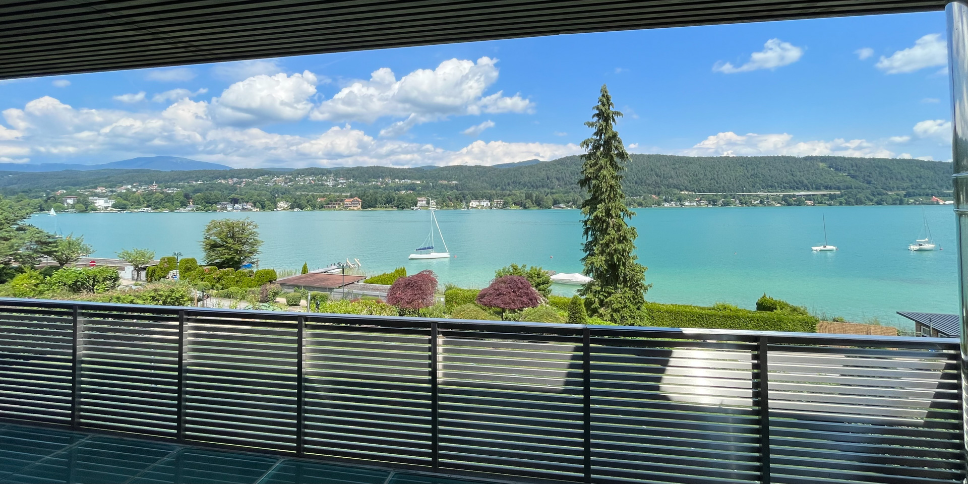 Panoramablick auf den Wörthersee mit Segelbooten von der Terrasse.