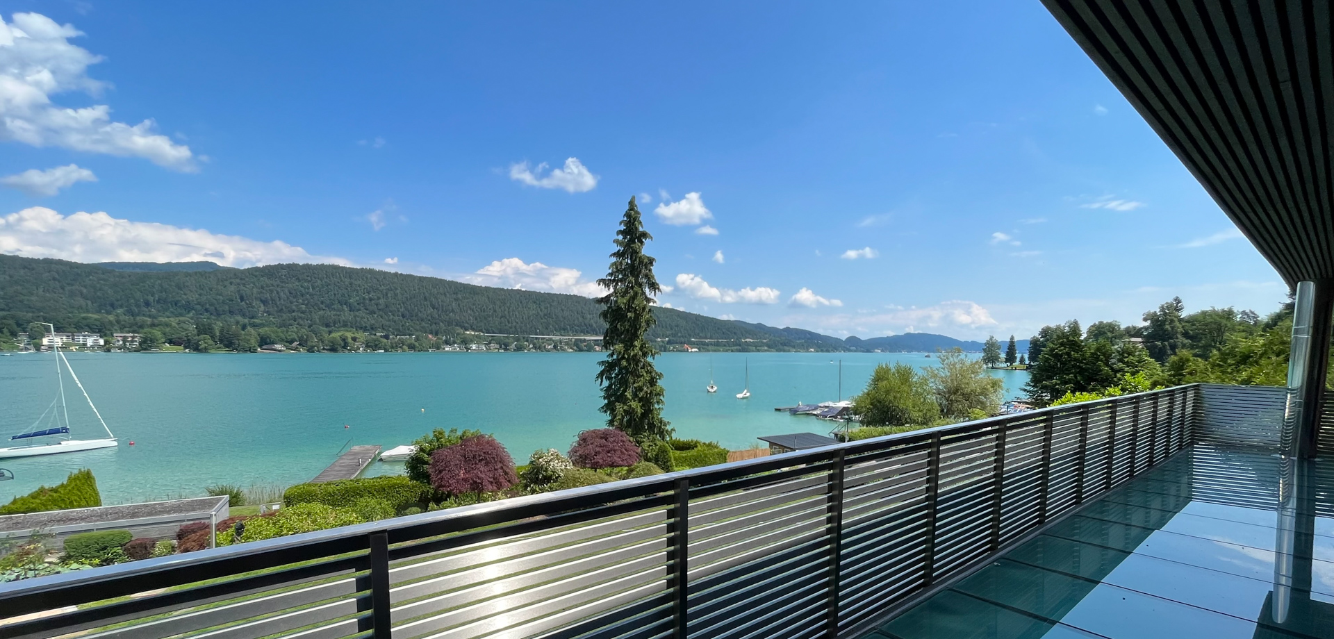 Moderne Terrasse mit Edelstahlgeländer und unverbaubarem Wörthersee-Panorama.