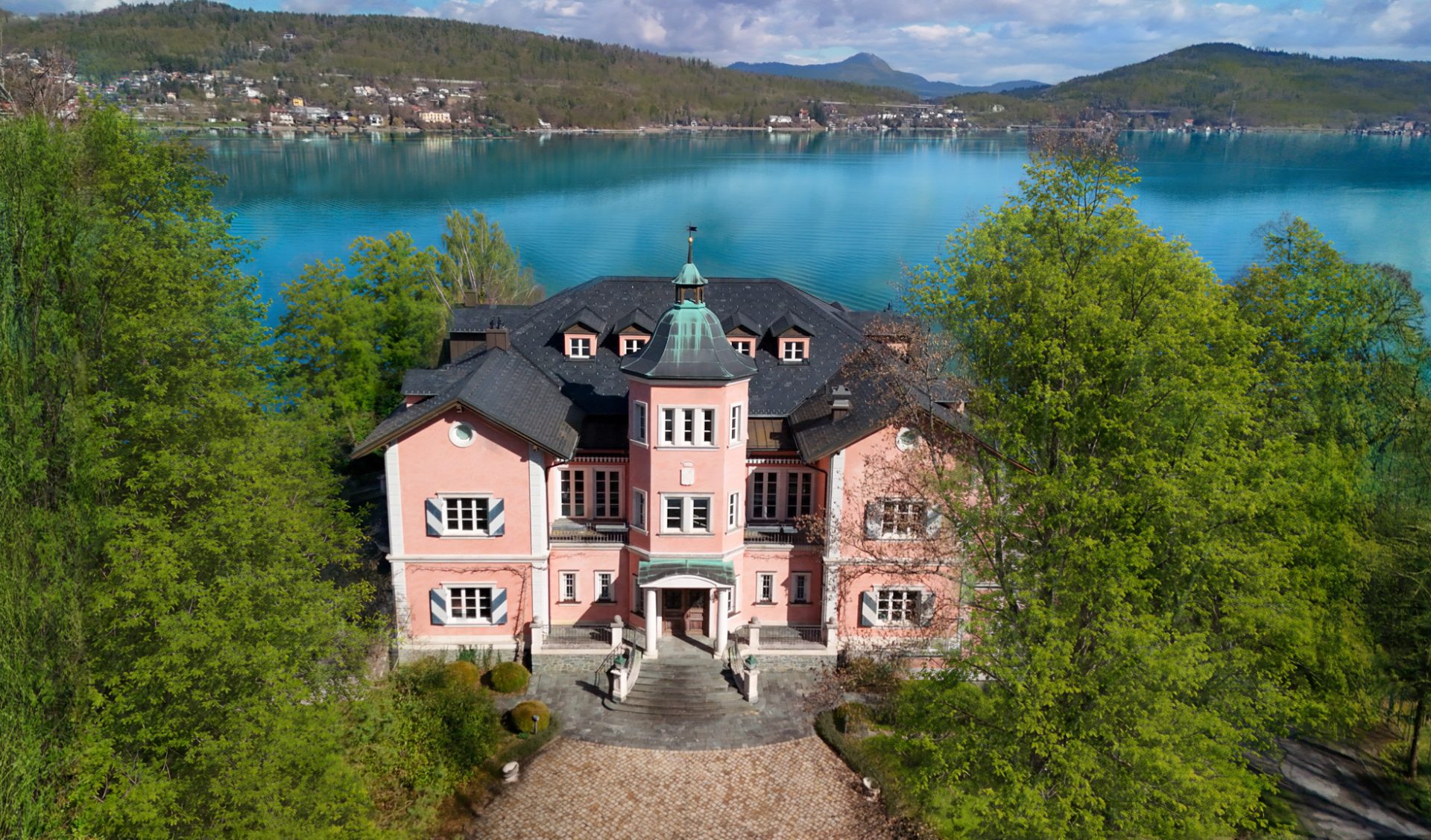 Historische Seevilla „The Grand" mit Kupferturm und direkter Uferlage am Wörthersee.