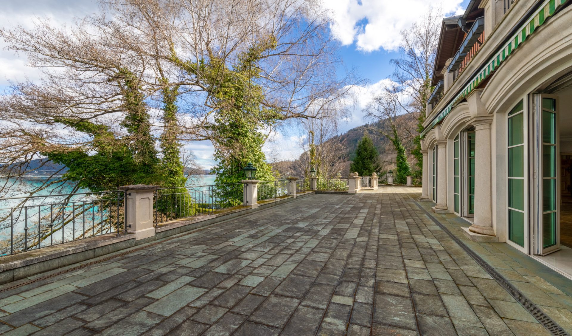 Weitläufige Steintetrasse mit Schmiedeeisenzaun und direktem Wörtherseeblick.